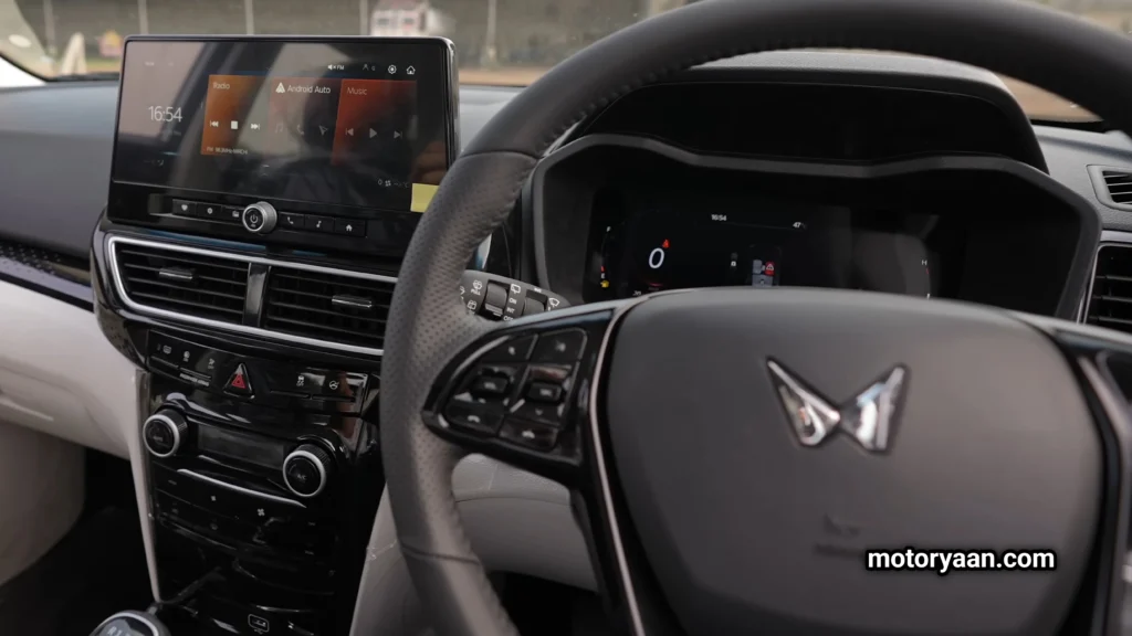Mahindra XUV-3XO dashboard view with touchscreen infotainment and steering wheel.