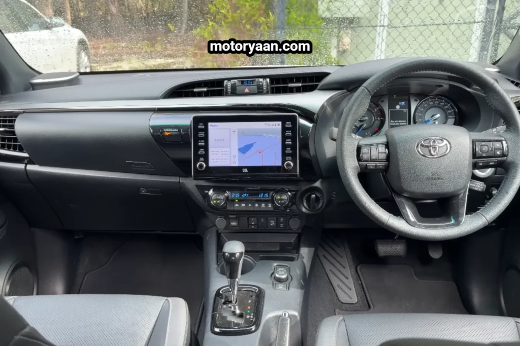 Old Toyota HiLux dashboard steering wheel infotainment system and center console.