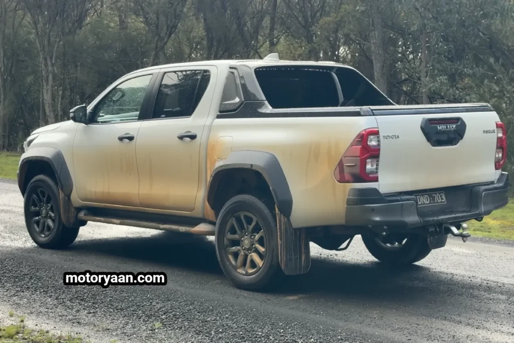 Old Toyota HiLux rear and side profile showing tailgate and halogen taillights.