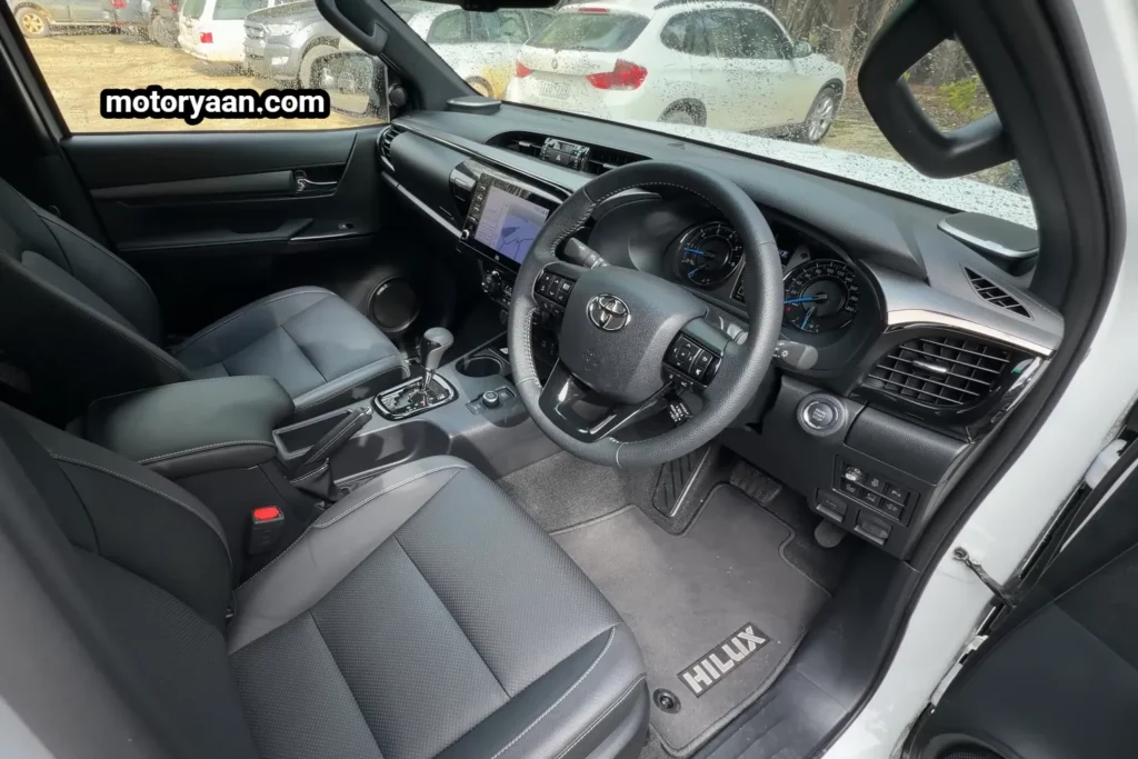 Old Toyota HiLux front interior dashboard steering infotainment system and center console.